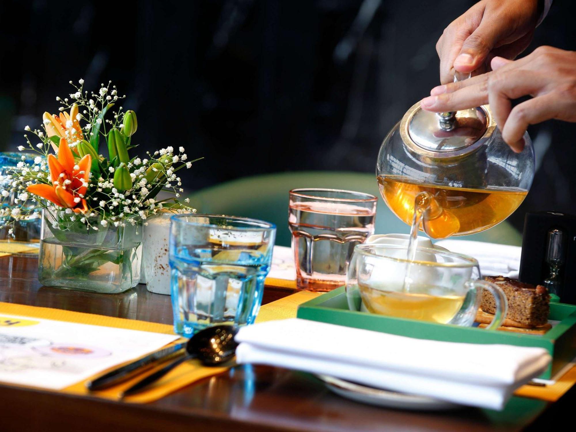 Novotel Kolkata Hotel&Residences Buitenkant foto A server pours tea at a restaurant